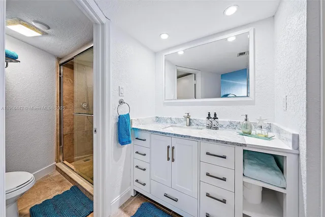 a bathroom with a granite countertop sink mirror and toilet