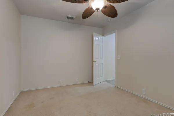 a view of an empty space and a ceiling fan