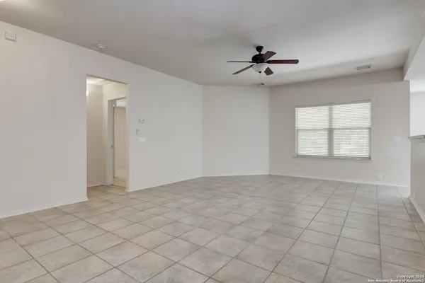 an empty room with windows and ceiling fan