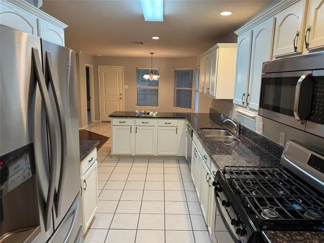 a kitchen with stainless steel appliances a stove a sink and a refrigerator