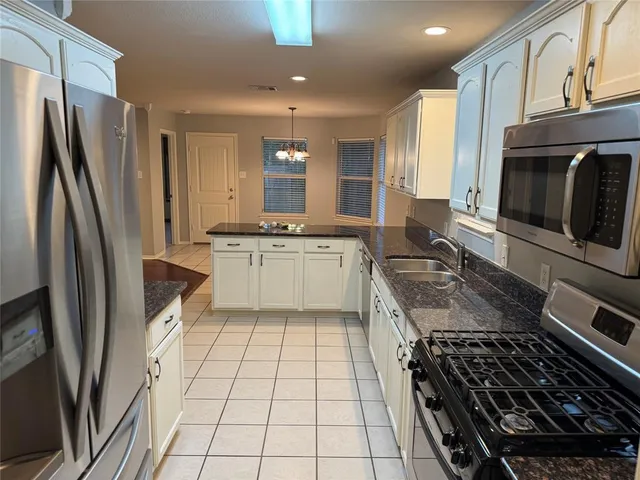 a kitchen with stainless steel appliances a stove a sink and a refrigerator