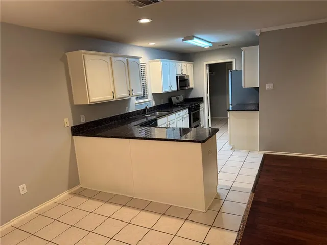 a view of a grey house with a yard and garage