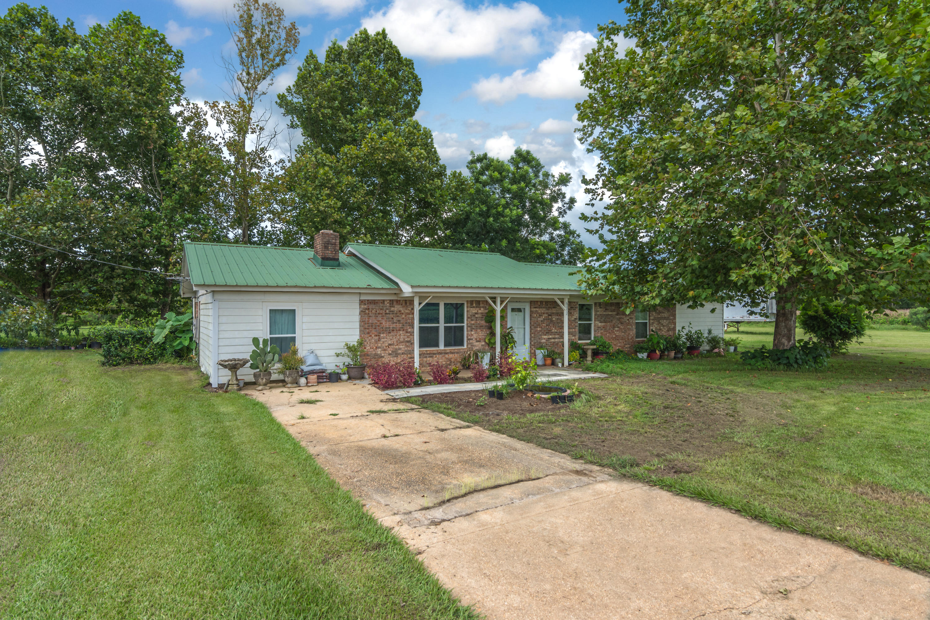 6072 Jack Stokes Road Baker, FL 32531 - Photo 3 of 29 a front view of a house with a garden and trees