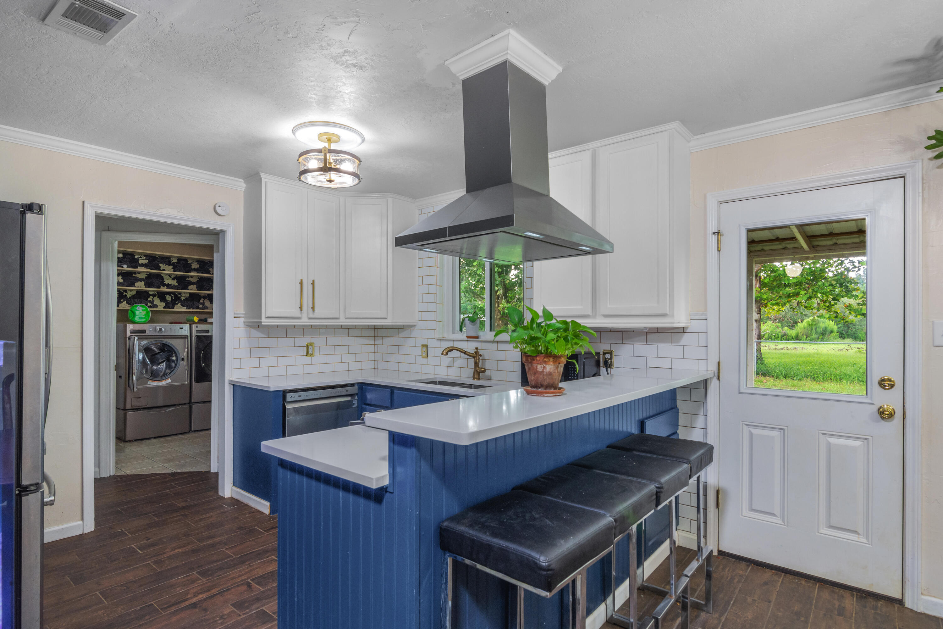 6072 Jack Stokes Road Baker, FL 32531 - Photo 23 of 29 a kitchen with stainless steel appliances a stove a chimney a sink and cabinets