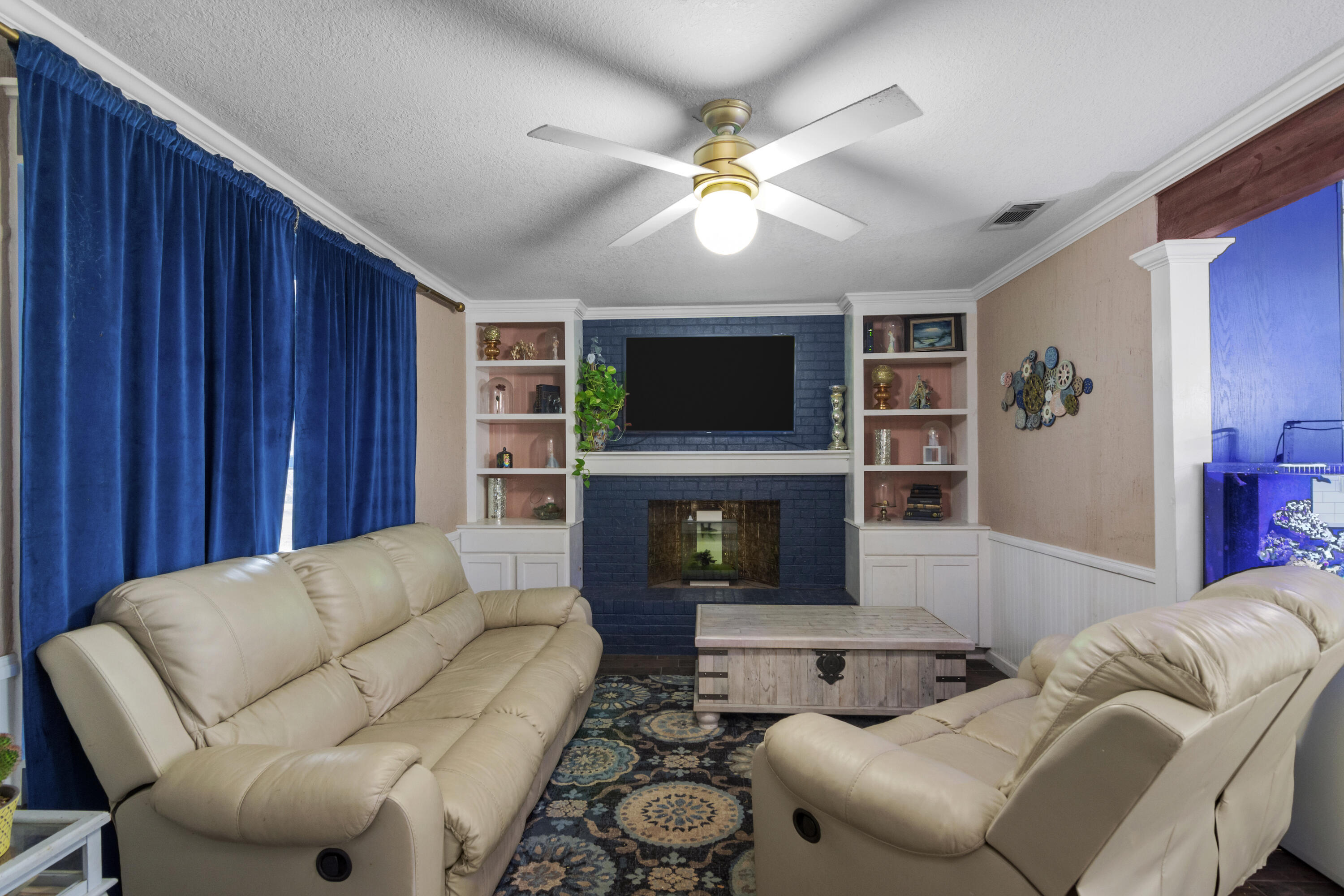 6072 Jack Stokes Road Baker, FL 32531 - Photo 5 of 29 a living room with furniture a flat screen tv and a fireplace