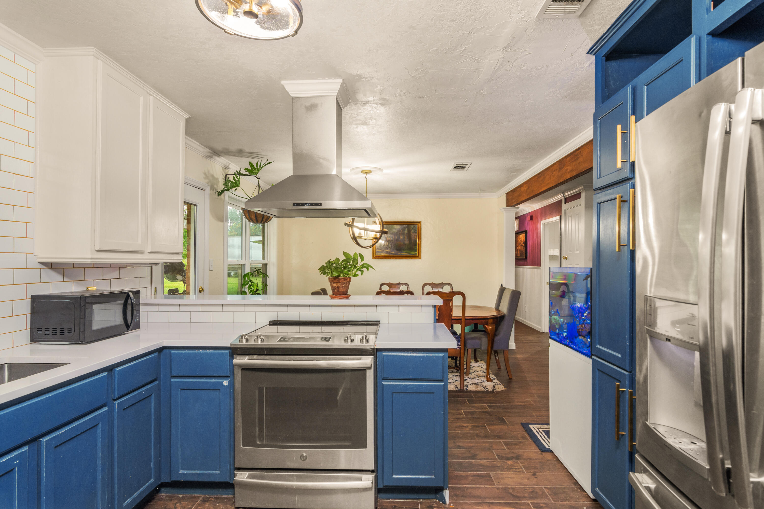 6072 Jack Stokes Road Baker, FL 32531 - Photo 9 of 29 a kitchen with stainless steel appliances granite countertop a refrigerator a stove oven and white cabinets with wooden floors