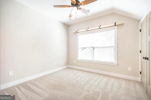 an empty room with a window and a fan