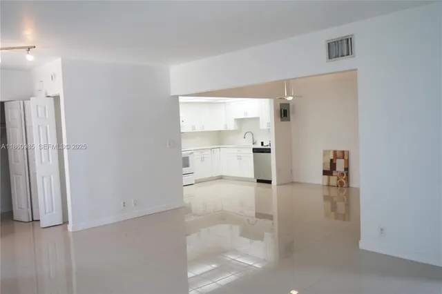 a view of a hallway view with wooden floor and a living room