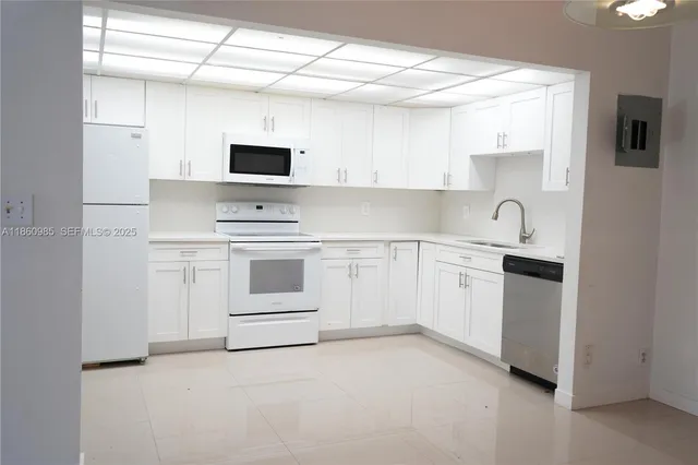 a kitchen with white cabinets and white appliances