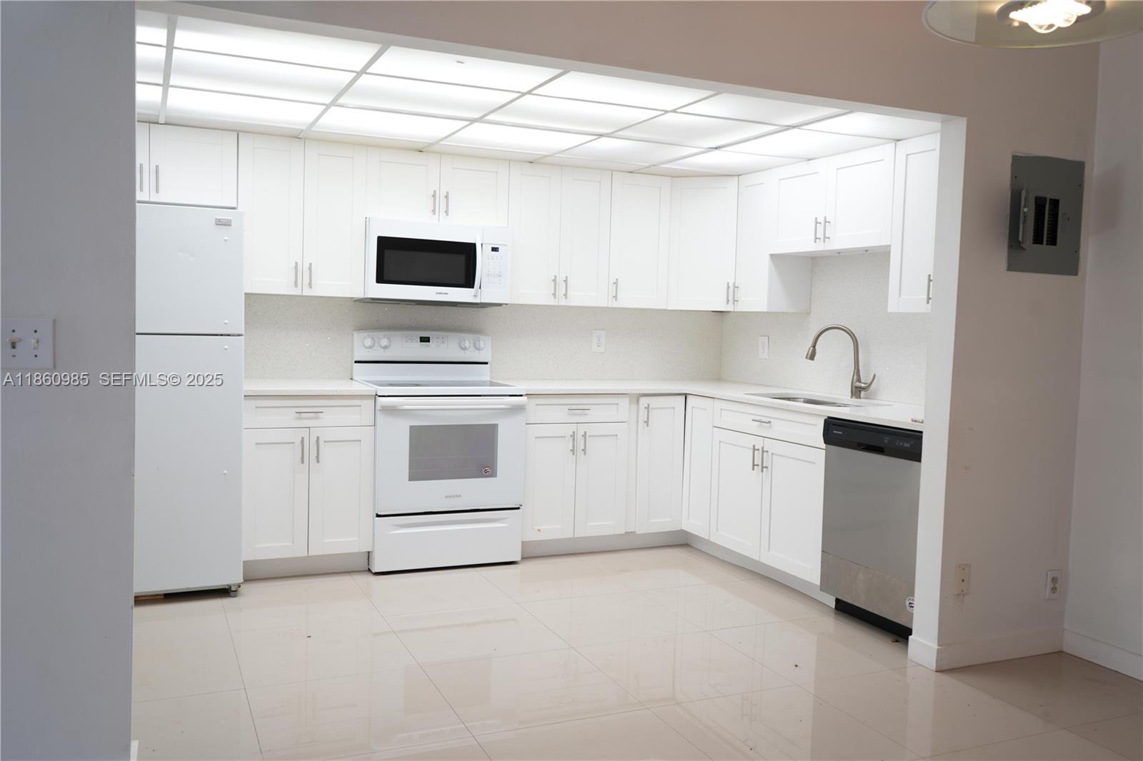 2800 South University Drive, Unit 2A Davie, FL 33328 - Photo 8 of 23 a kitchen with white cabinets and white appliances