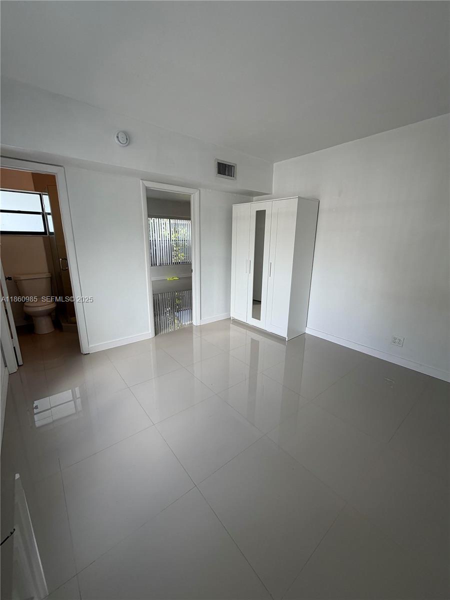 2800 South University Drive, Unit 2A Davie, FL 33328 - Photo 10 of 23 a view of an empty room with wooden floor and a window