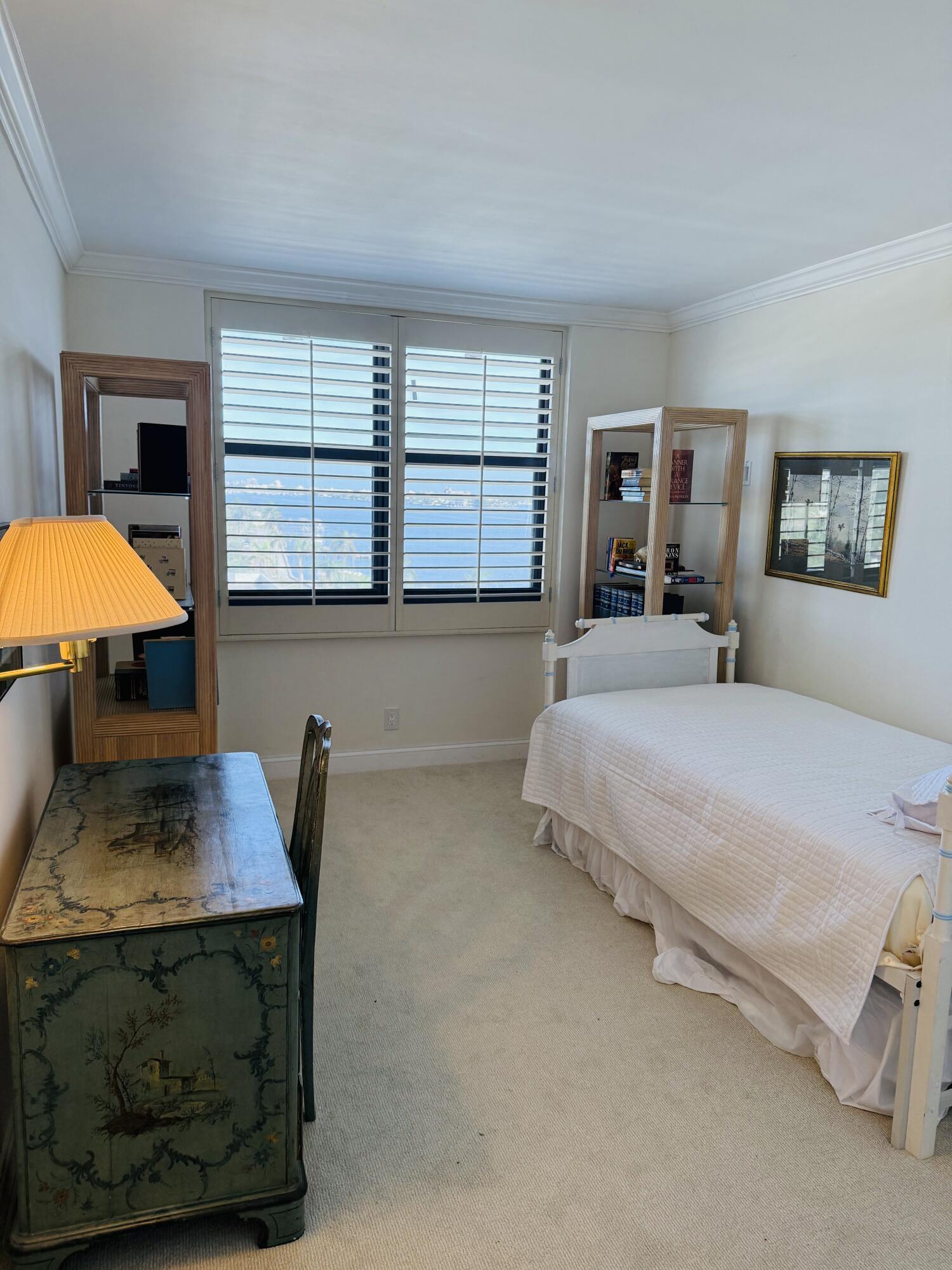 3800 Washington Road, Unit 907 West Palm Beach, FL 33405 - Photo 7 of 8 a bedroom with a bed a dresser and next to a window