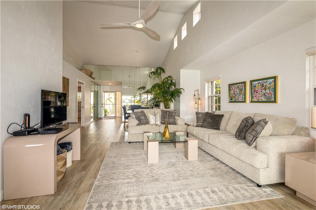 2608 Sailors Way, Unit 122 Naples, FL 34109 - Photo 17 of 47 a living room with furniture a flat screen tv and a fireplace