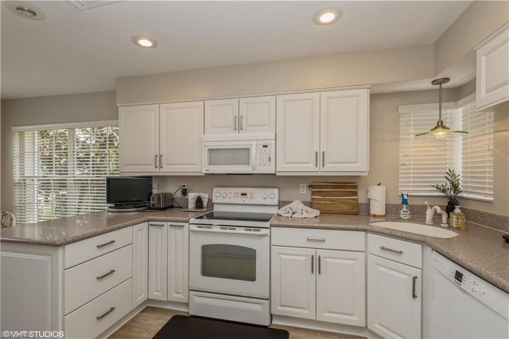 2608 Sailors Way, Unit 122 Naples, FL 34109 - Photo 20 of 47 a kitchen with granite countertop white cabinets white appliances and sink