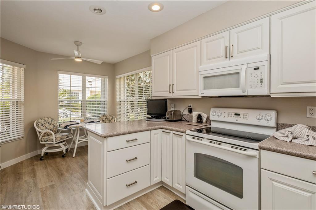 2608 Sailors Way, Unit 122 Naples, FL 34109 - Photo 22 of 47 a kitchen with white cabinets and white appliances