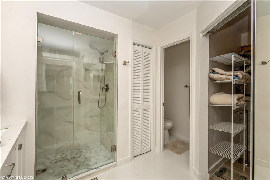 2608 Sailors Way, Unit 122 Naples, FL 34109 - Photo 29 of 47 a bathroom with a glass shower door