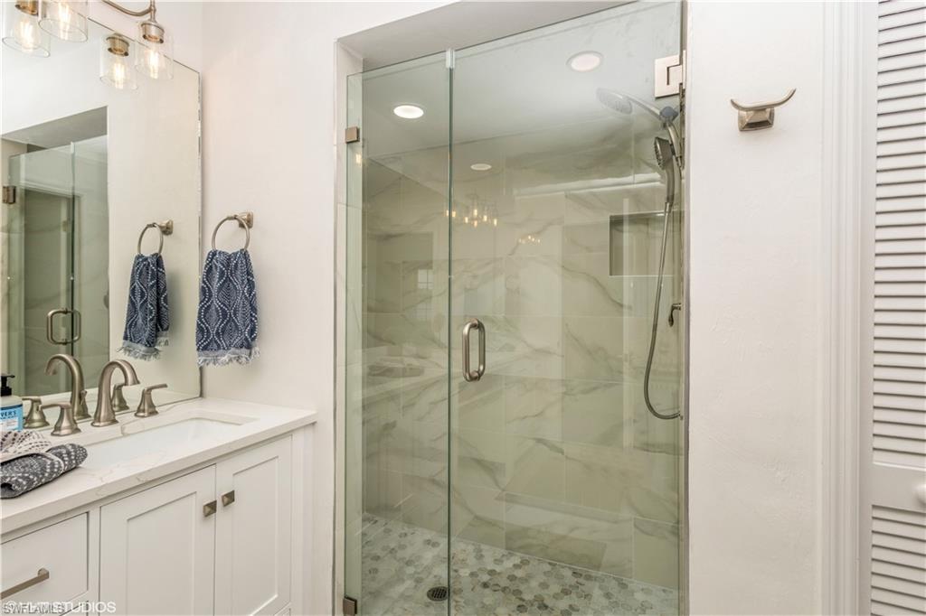 2608 Sailors Way, Unit 122 Naples, FL 34109 - Photo 30 of 47 a bathroom with a shower sink and mirror