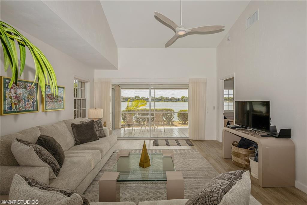 2608 Sailors Way, Unit 122 Naples, FL 34109 - Photo 6 of 47 a living room with furniture a flat screen tv and a large window