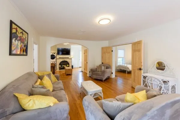 a living room with furniture fireplace and a large window