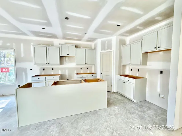 a large white kitchen with kitchen island a sink a stove and a refrigerator