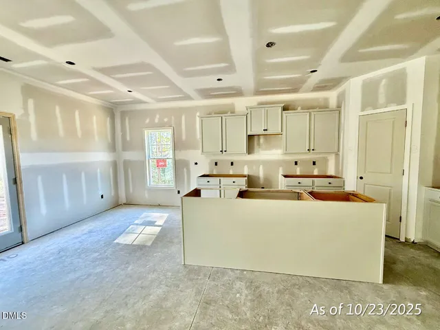 a large white kitchen with a stove a sink a refrigerator and a cabinets