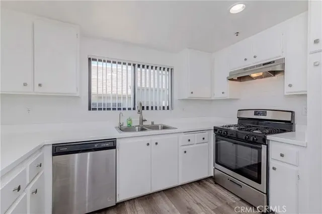 a kitchen with white cabinets and appliances