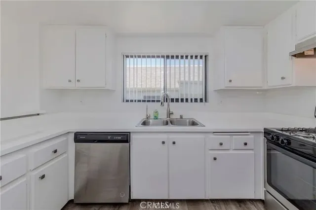 a kitchen with granite countertop white cabinets and white appliances