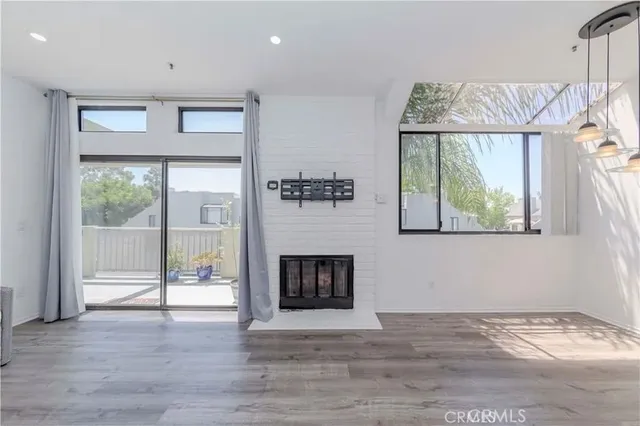 a view of an empty room with a fireplace and a window