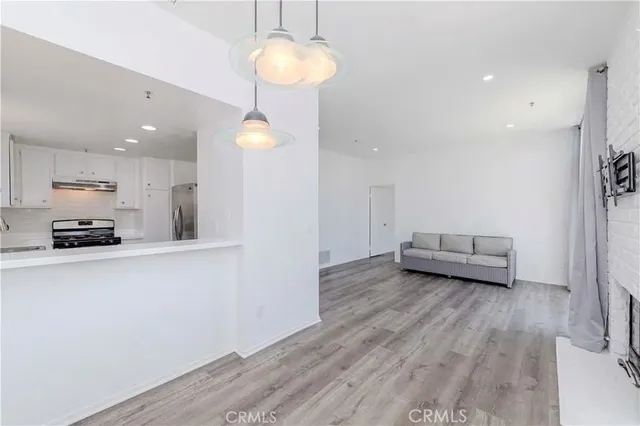 a view of a living room a wooden floor and a chandelier