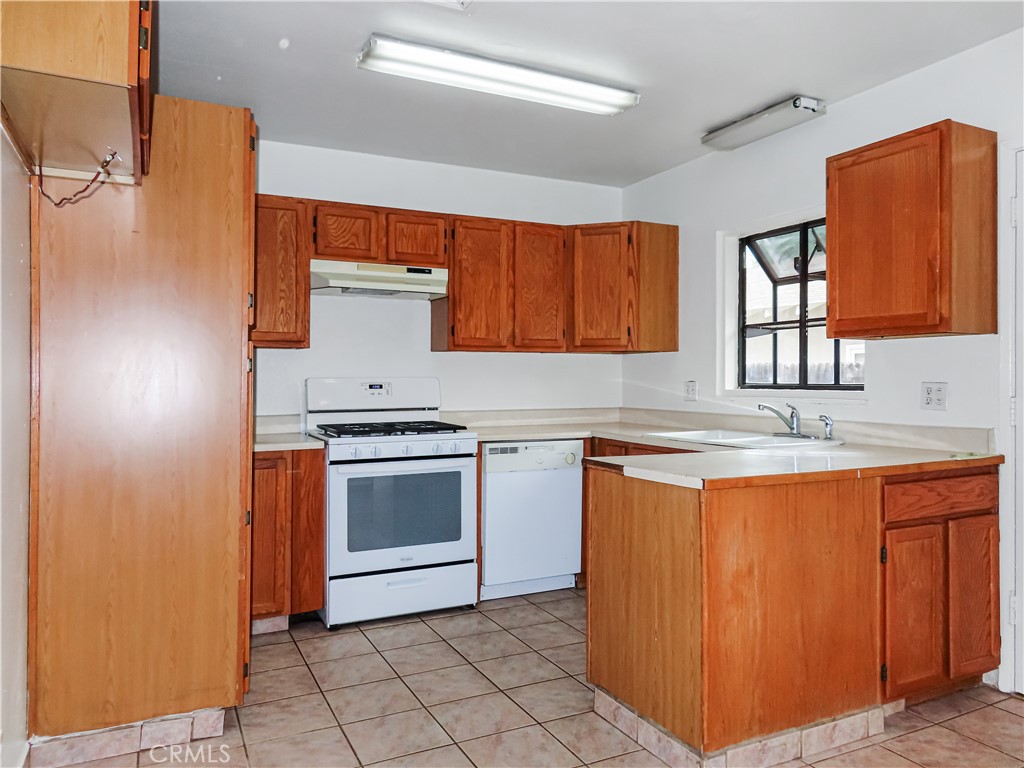 6688 Montclair Drive Riverside, CA 92504 - Photo 9 of 21 a kitchen with granite countertop a sink stainless steel appliances and cabinets