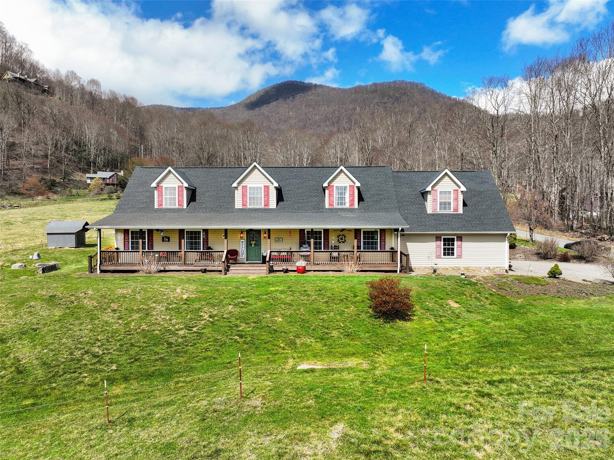 371 Ned Cove Road Waynesville, NC 28785 - Photo 1 of 44 a view of a big house with a big yard and large trees