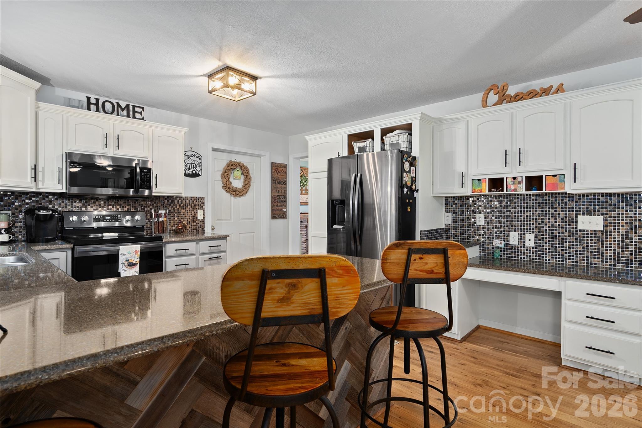 371 Ned Cove Road Waynesville, NC 28785 - Photo 14 of 44 a kitchen with stainless steel appliances kitchen island granite countertop a refrigerator and a stove top oven