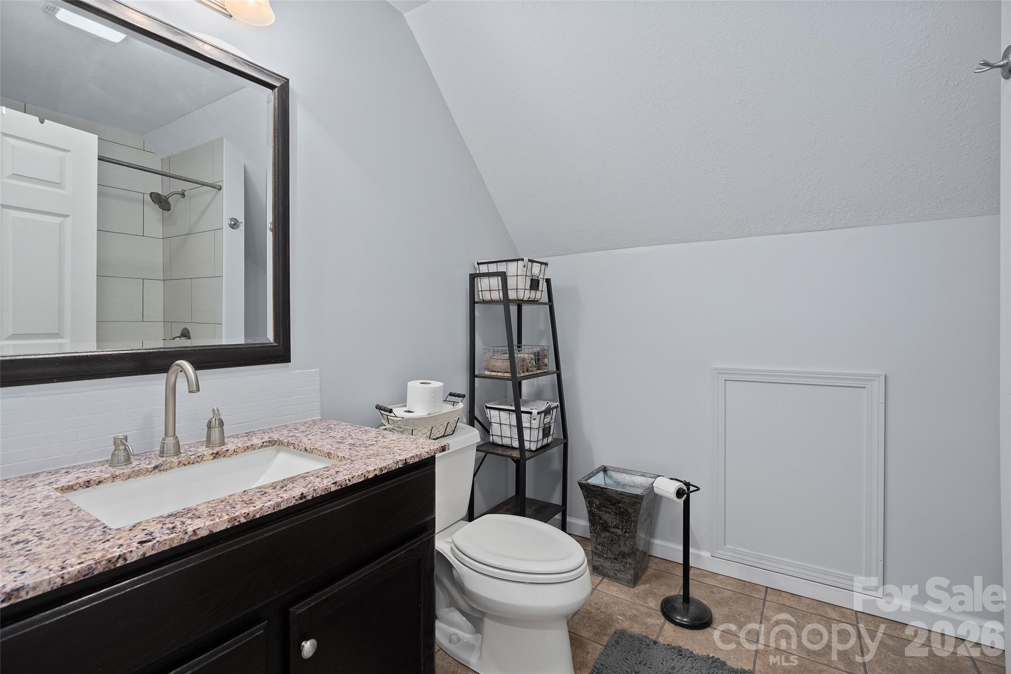 371 Ned Cove Road Waynesville, NC 28785 - Photo 32 of 44 a bathroom with a granite countertop sink toilet and mirror