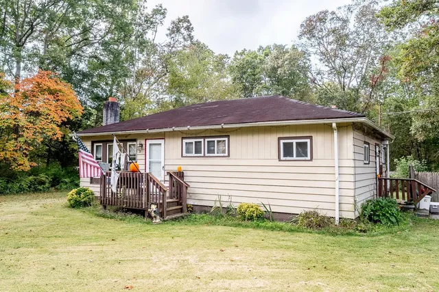 a view of a house with a yard and sitting area