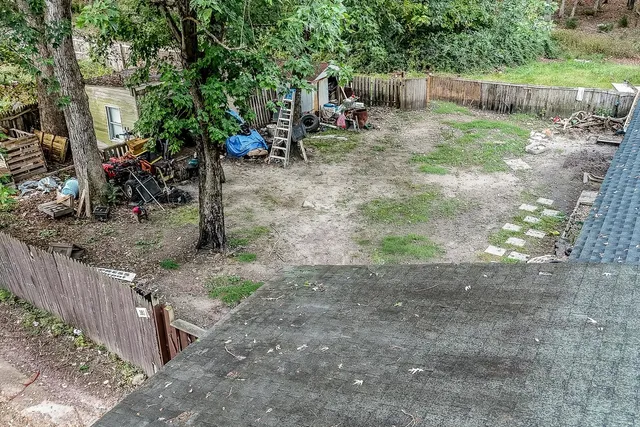 a view of backyard with wooden fence