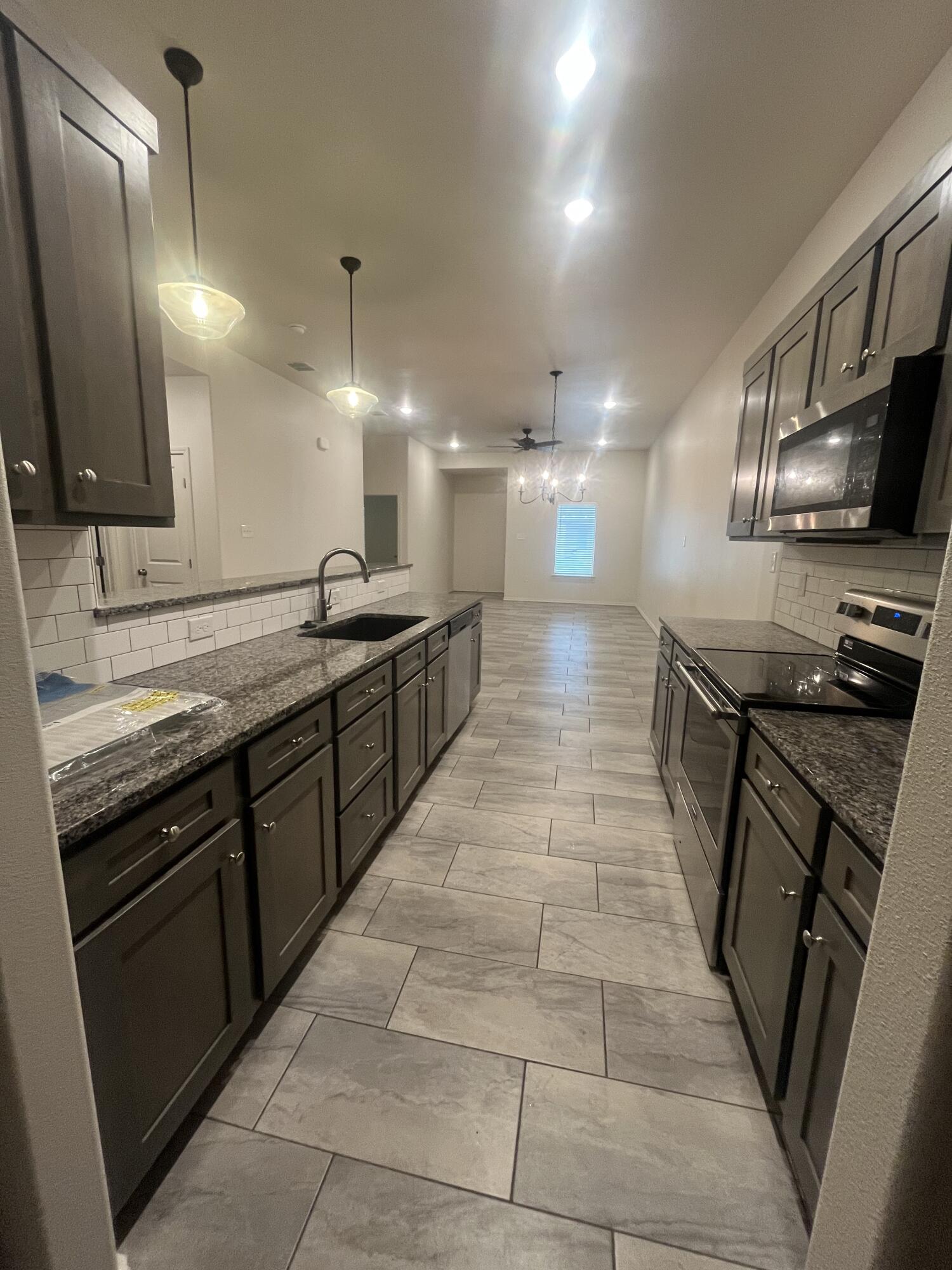 2611 136th Street Lubbock, TX 79423 - Photo 5 of 13 a large kitchen with stainless steel appliances lots of counter space and a sink