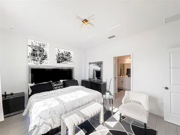 a bed sitting in a bedroom and table chair