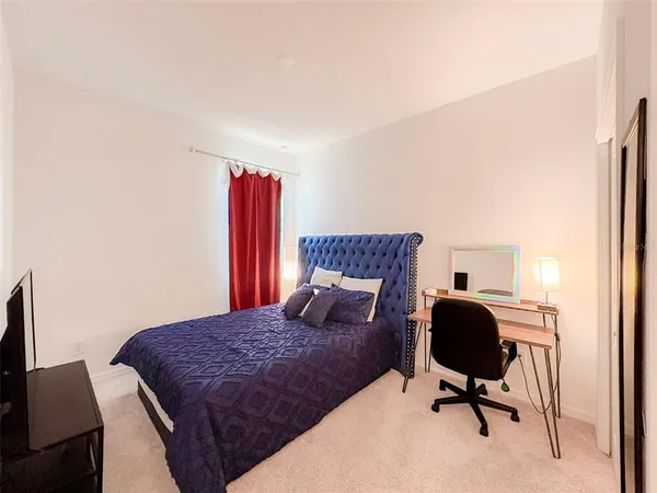 a bedroom with a large bed and a chair