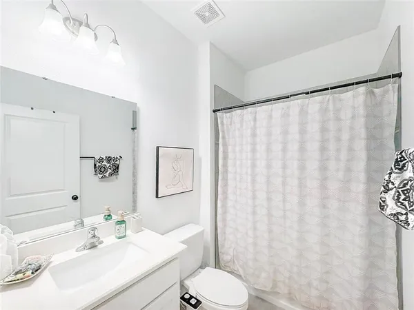 a bathroom with a sink vanity mirror and toilet