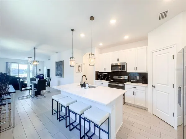 a kitchen with a sink a counter top space stainless steel appliances and cabinets