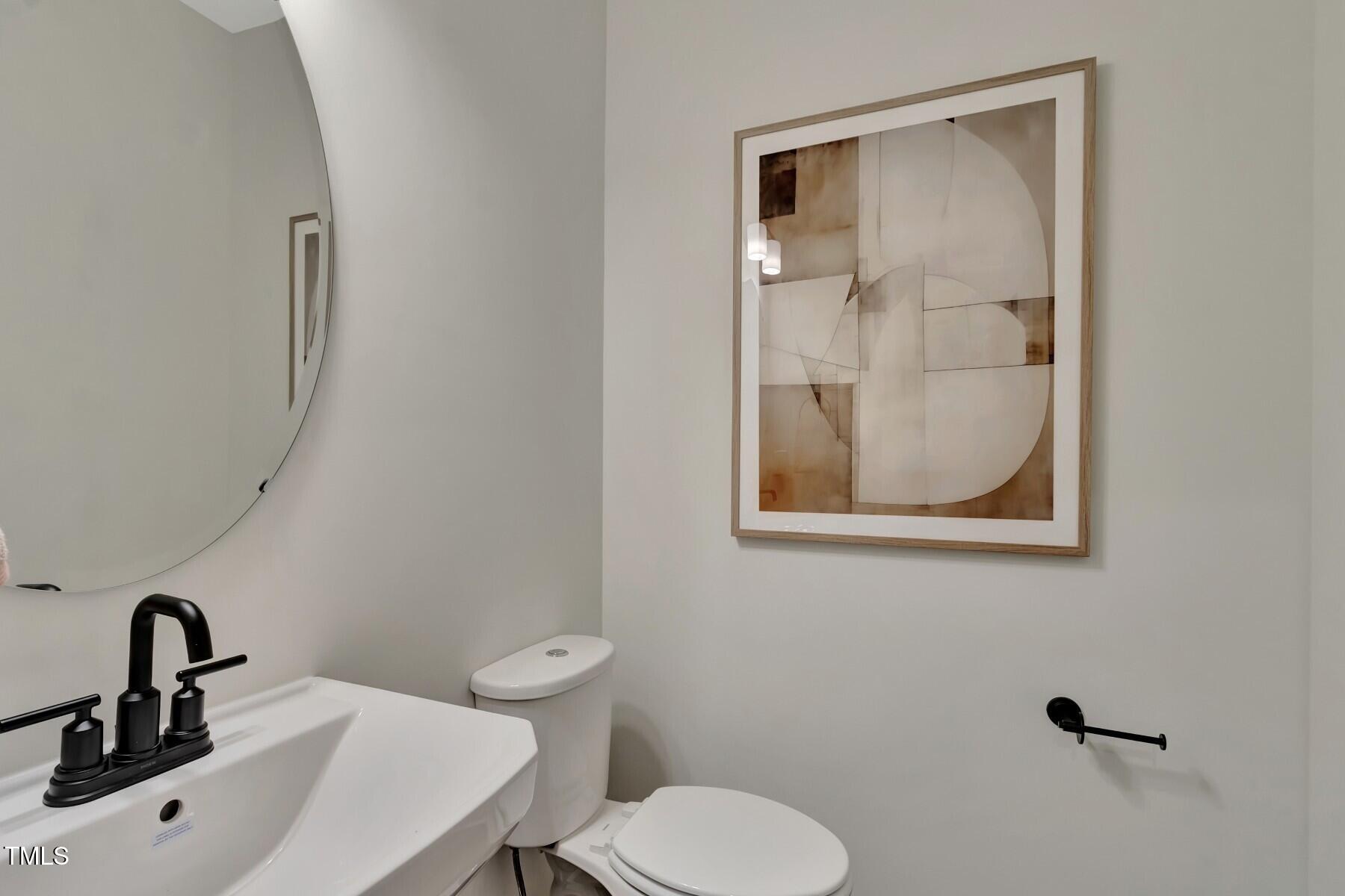 6972 Doddridge Lane Cary, NC 27519 - Photo 34 of 34 a bathroom with a toilet sink and mirror