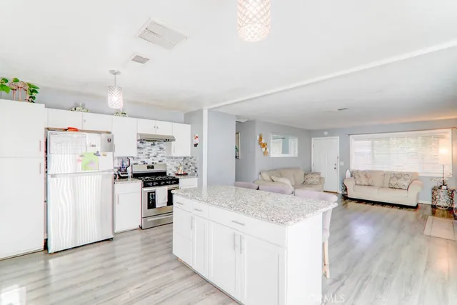 a kitchen with refrigerator cabinets and wooden floor
