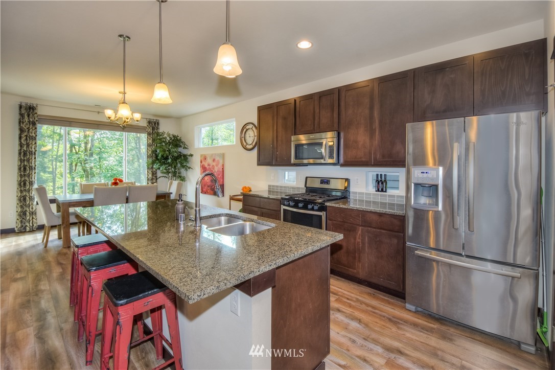 17503 3rd Avenue Southeast Bothell, WA 98012 - Photo 3 of 22 a kitchen with stainless steel appliances granite countertop a refrigerator a stove a sink dishwasher and a refrigerator with wooden floor