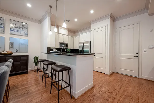 a kitchen with stainless steel appliances kitchen island granite countertop a table and chairs in it