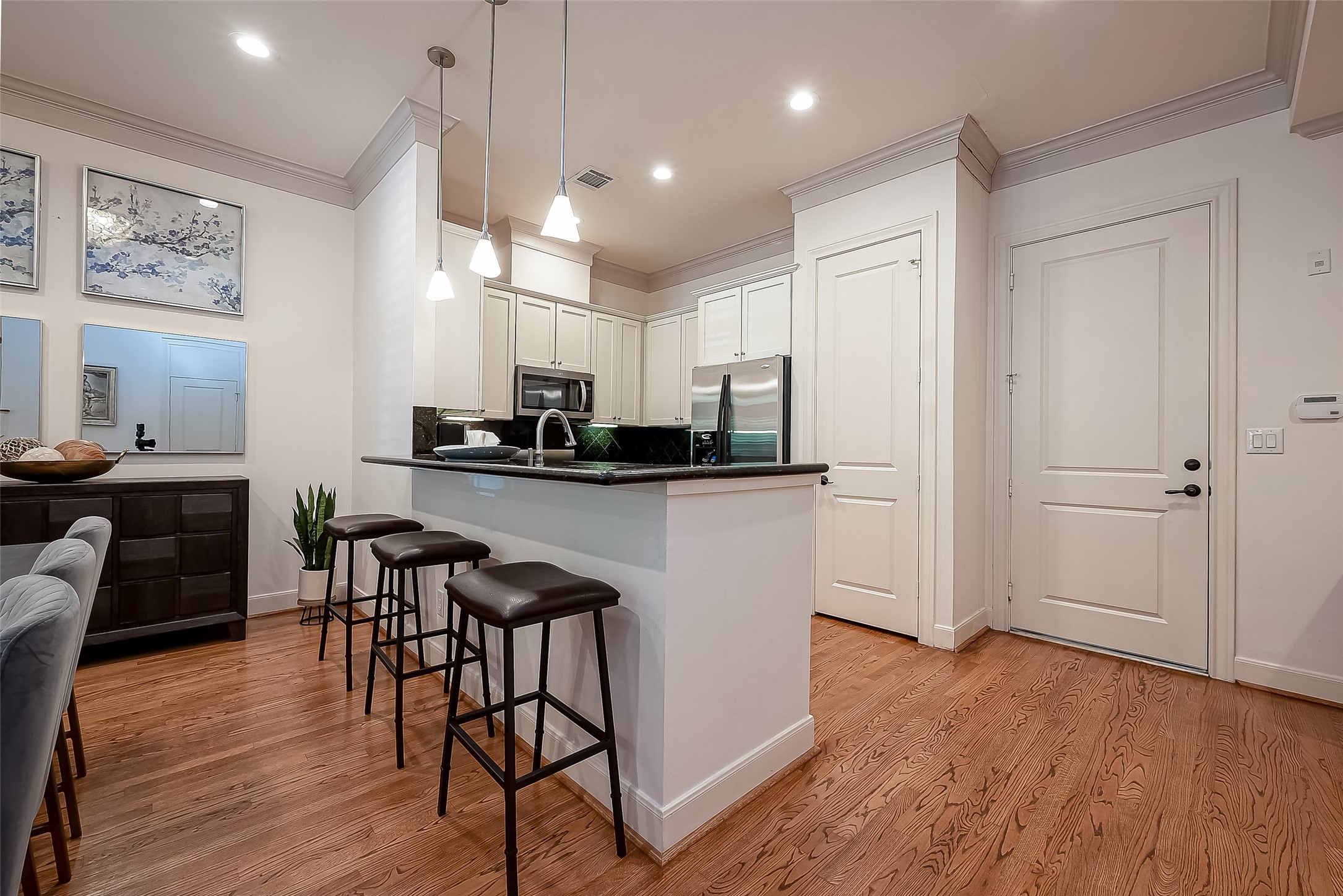 56 Riva Row The Woodlands, TX 77380 - Photo 13 of 36 a kitchen with stainless steel appliances kitchen island granite countertop a table and chairs in it