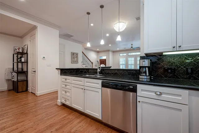 a kitchen with stainless steel appliances granite countertop a sink a stove and a wooden floors