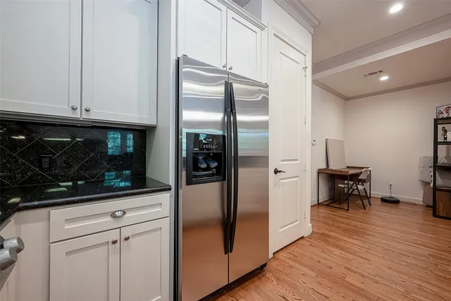 a kitchen with granite countertop a refrigerator and a stove top oven