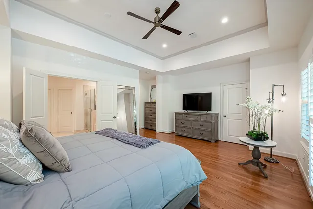 a bedroom with a bed a flat screen tv and a couch