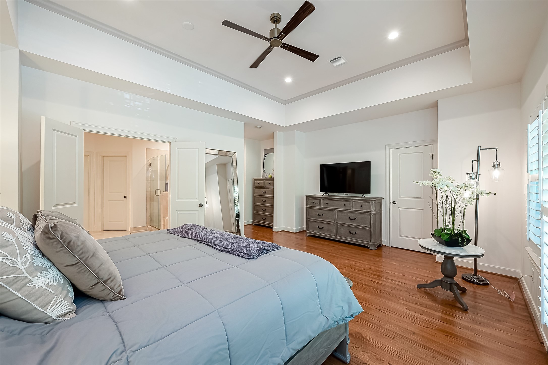 56 Riva Row The Woodlands, TX 77380 - Photo 23 of 36 a bedroom with a bed a flat screen tv and a couch