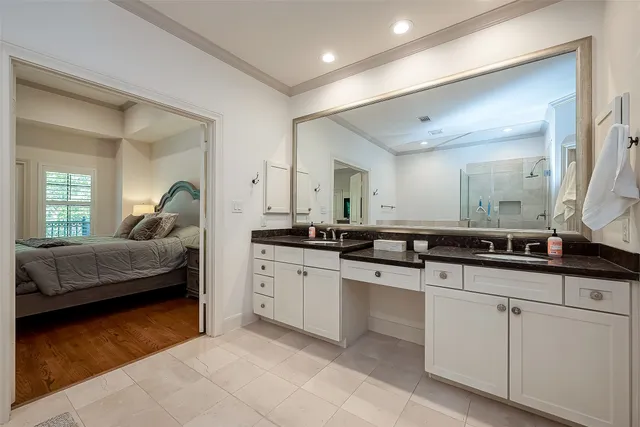 a en suite bathroom with a double vanity sink and a mirror